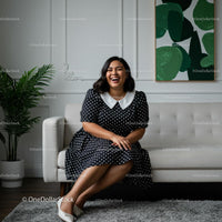 Smiling Woman in Polka Dot Dress in Cozy Living Room