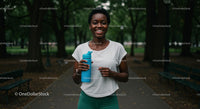 Woman Jogging in Park with Water Bottle and Smile