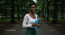 Smiling Woman Enjoying Exercise in a Green Park Setting