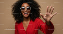Smiling Woman with Curly Hair and Sunglasses Waving