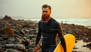 Bearded Surfer with Board on Rocky Sunset Beach
