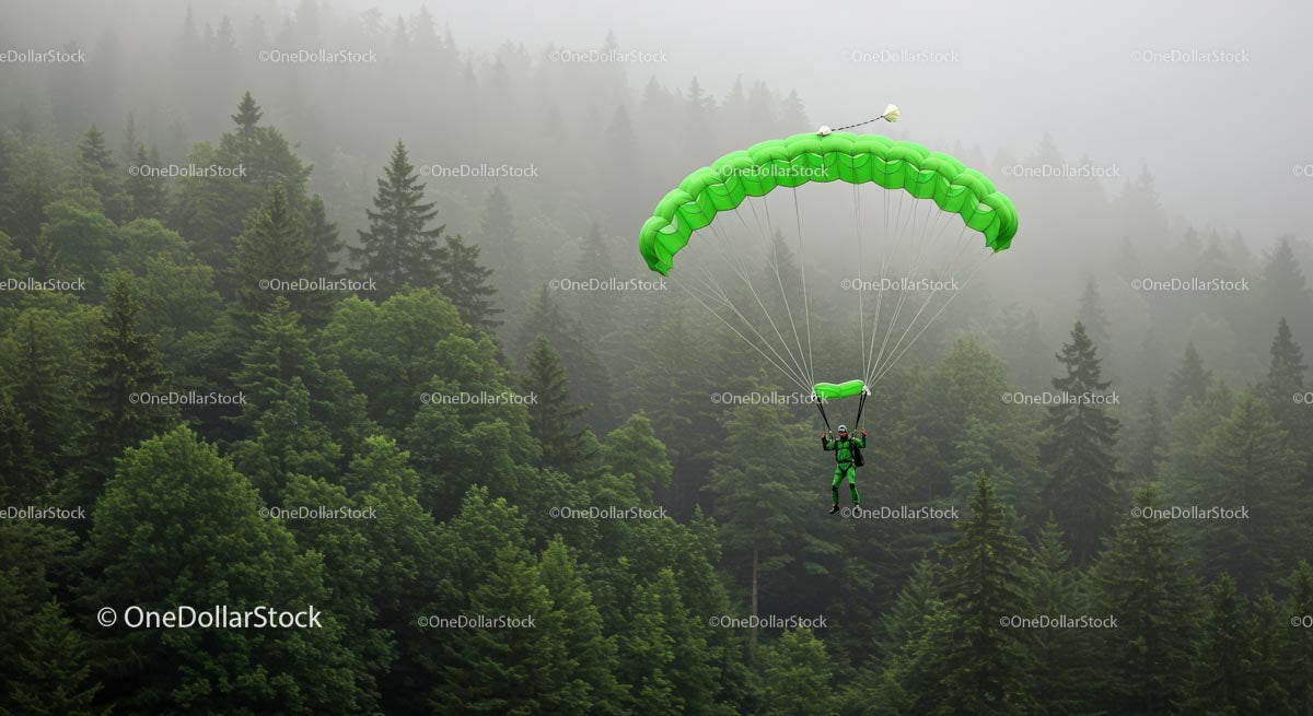 Skydiver Descending with Green Parachute over Misty Forest