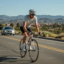 Cyclist Riding Along Scenic Mountain Road on a Sunny Day