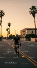 Cyclist Riding Down a Palm-Lined Street at Sunset