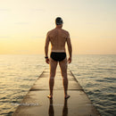 Swimmer Standing on a Pier at Sunset Overlooking the Ocean