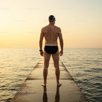 Swimmer Standing on a Pier at Sunset Overlooking the Ocean