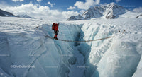 Expedition Climber Crossing Glacier Crevasse on Rope Bridge