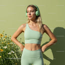 Woman in Green Workout Gear with Headphones in a Floral Setting