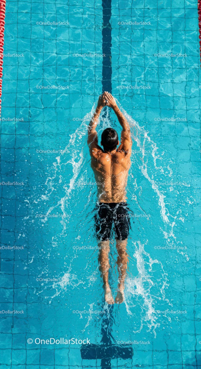 Male Swimmer Practicing Backstroke in Blue Pool