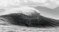 Silhouette of a Surfer Riding a Massive Ocean Wave
