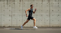 Athletic Man Running Against a Concrete Wall in Urban Setting