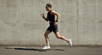Male Athlete Running Against Concrete Wall on Sunny Day