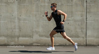 Male Athlete Running Against Concrete Wall on Sunny Day