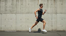 Athletic Man Jogging Along Urban Concrete Wall