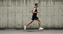 Athletic Man Running Along Urban Concrete Wall