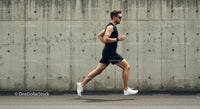 Athletic Man Running Along Urban Concrete Wall