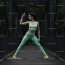 Fit Woman Stretching on an Old Bridge in Athletic Wear