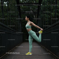 Woman Stretching on Iron Bridge in Green Activewear