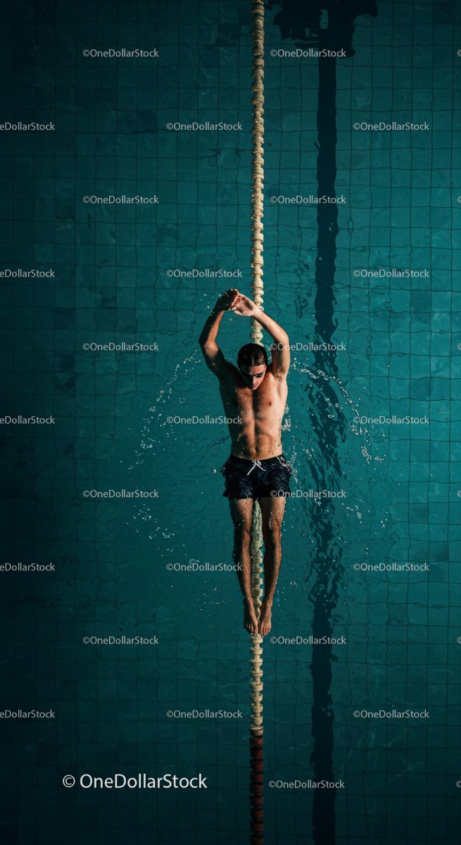 Male Swimmer Training in a Clear Blue Swimming Pool