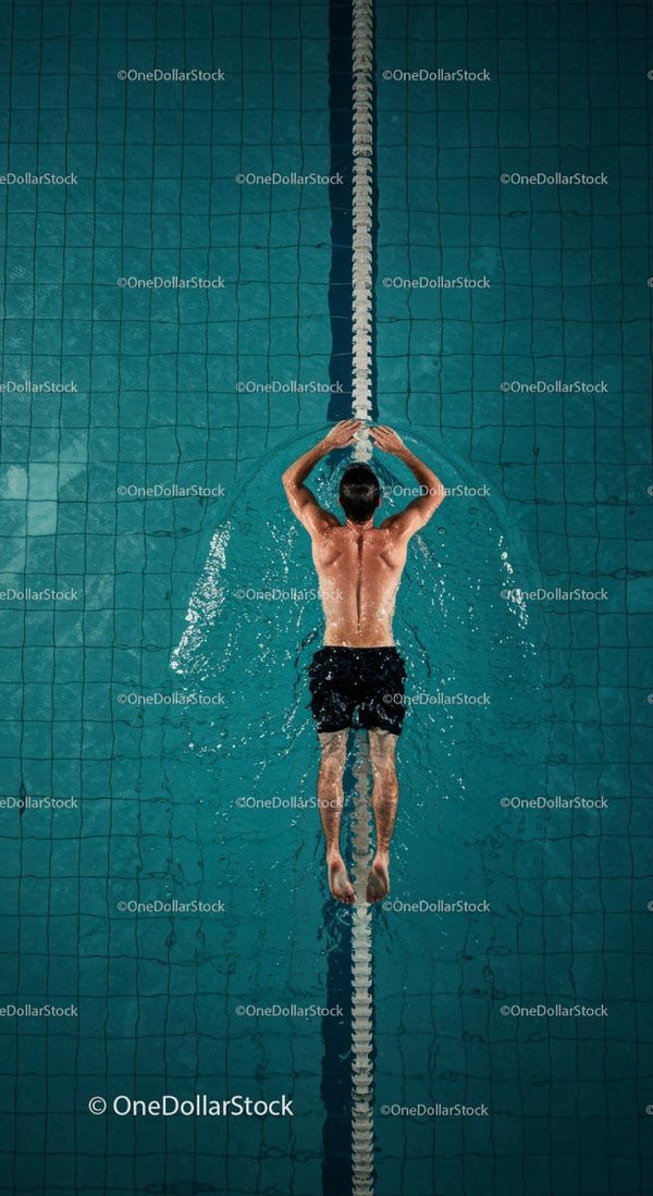 Male Swimmer in a Pool Performing Backstroke