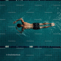 Male Athlete Freestyle Swimming in a Pool Lane