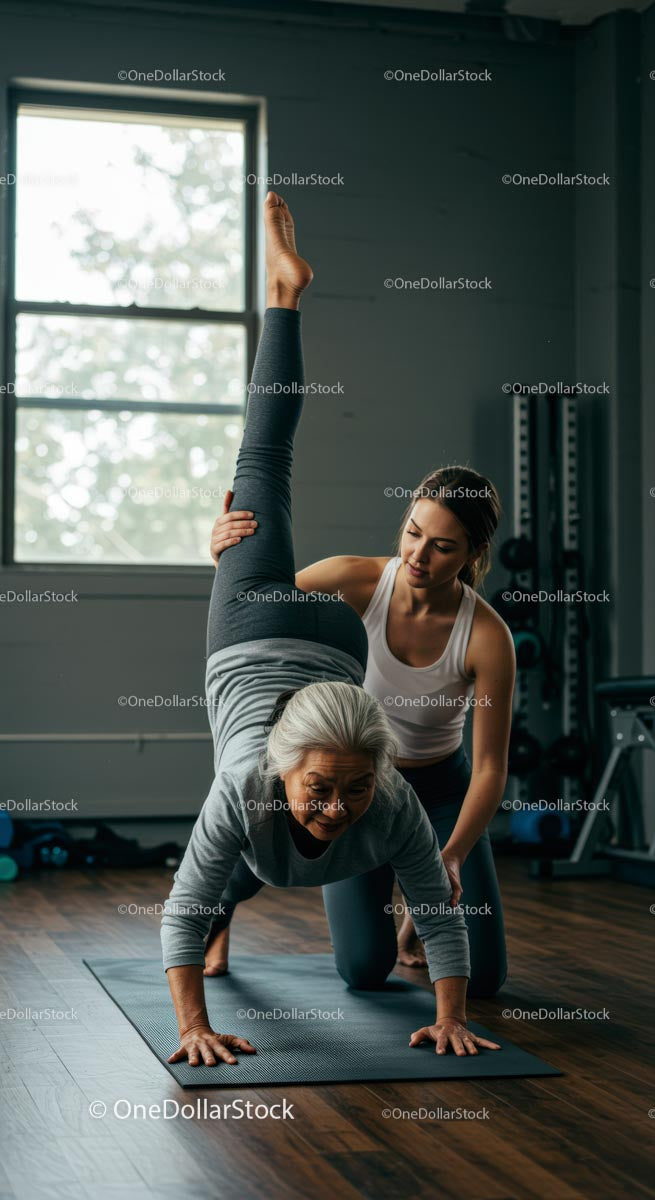 Senior Woman Assisted in Yoga Pose by Trainer