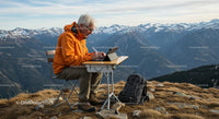 Senior Man Working Remotely in a Scenic Mountain Landscape