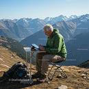 Senior Man Working on Tablet in Majestic Mountain Scenery