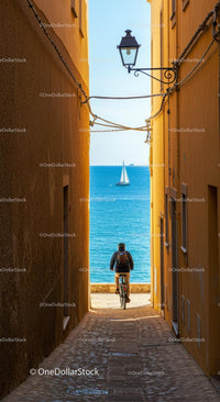 Cyclist in a Narrow Alley with Stunning Sea View