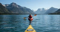 Kayaker on Serene Mountain Lake with Stunning Peaks