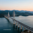 Majestic Suspension Bridge at Sunset Over Serene Waters