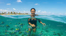 Woman Snorkeling with Tropical Fish in Clear Azure Waters