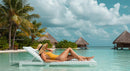 Woman Relaxing by Tropical Pool in Yellow Swimsuit