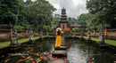 Woman in Yellow Dress at Balinese Reflection Pool with Koi Fish