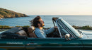 Man Driving Convertible Car Along Scenic Coastline