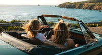 Friends on a Coastal Road Trip in Convertible Car
