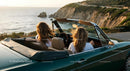 Friends on a Coastal Road Trip in Convertible Car
