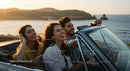 Friends on a Coastal Road Trip in Convertible Car