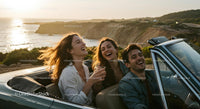 Friends on a Coastal Road Trip in Convertible Car