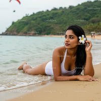 Woman Relaxing on a Tropical Beach with a White Frangipani