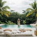 Woman Relaxing by Tropical Infinity Pool Surrounded by Lush Greenery