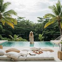Woman Relaxing by Tropical Infinity Pool Surrounded by Lush Greenery
