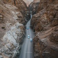 Cars Navigating a Rocky Mountain Pass in a Narrow Canyon