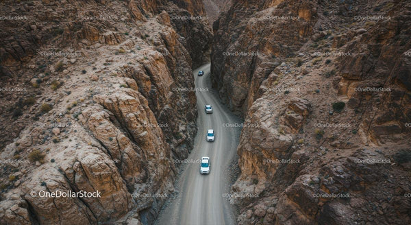 Aerial View of Cars Navigating a Rugged Canyon Road