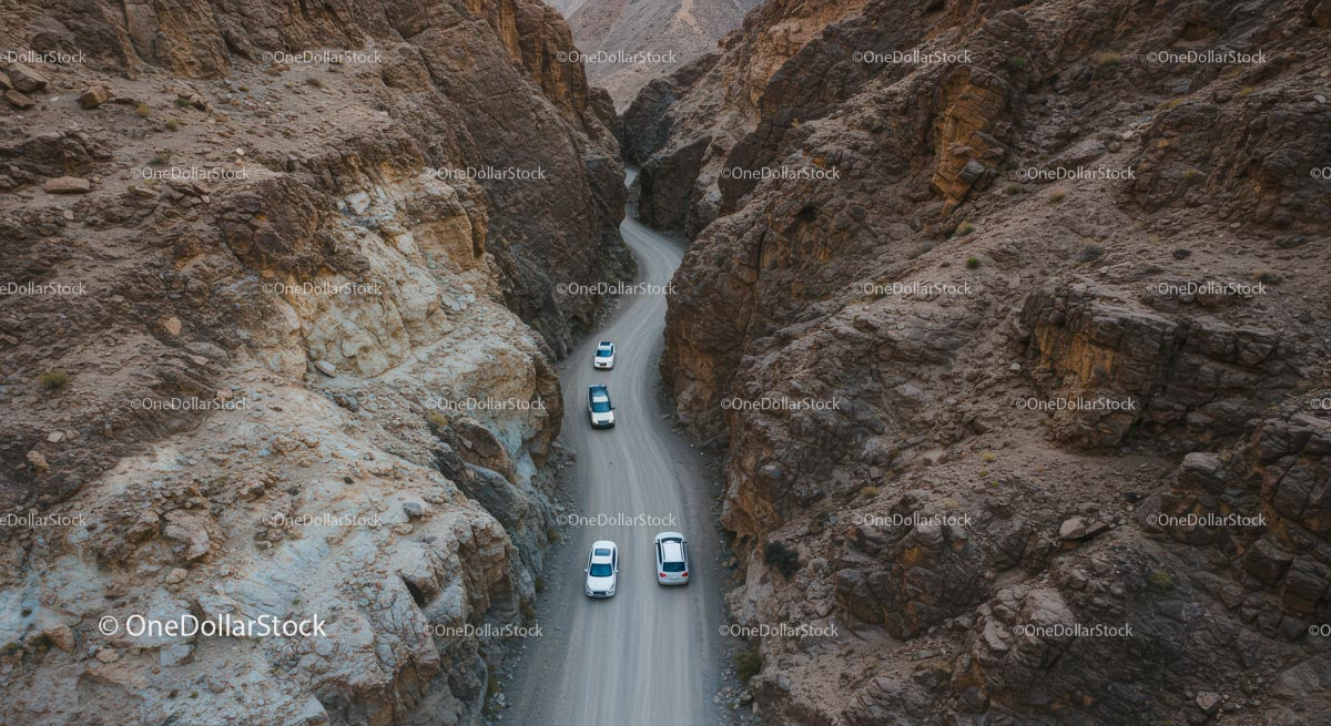 Convoy of Cars on a Winding Desert Canyon Road