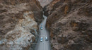 Convoy of Cars on a Winding Desert Canyon Road