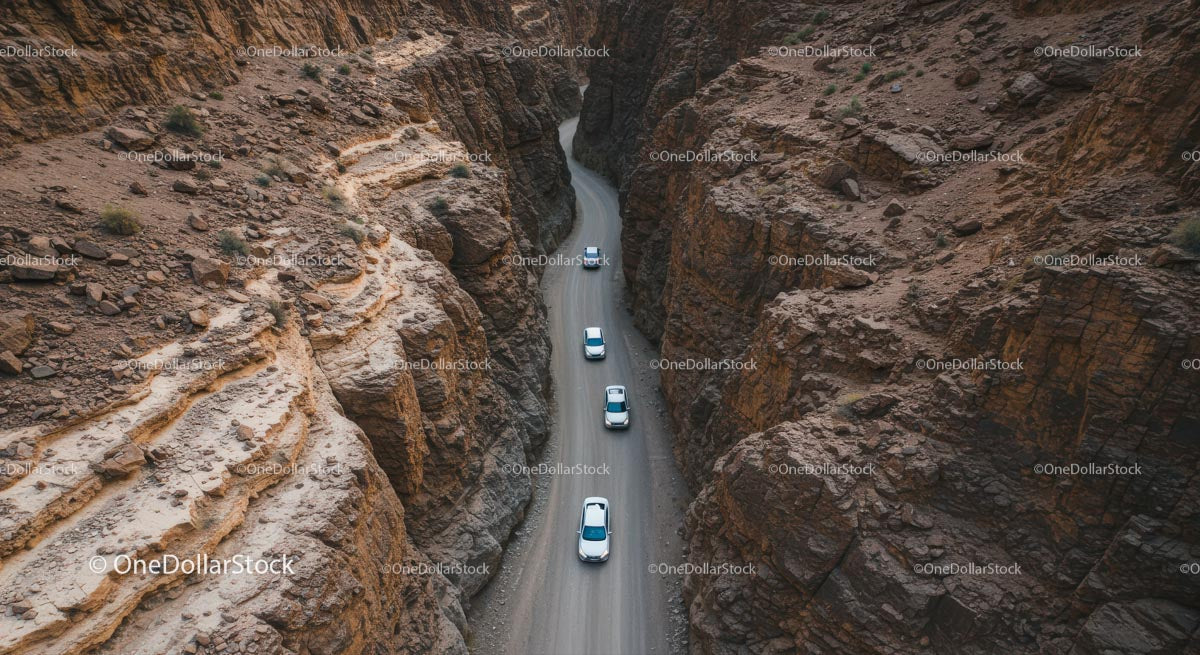 Aerial View of Cars Navigating a Rocky Desert Canyon