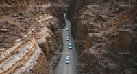 Aerial View of Cars Navigating a Rocky Desert Canyon