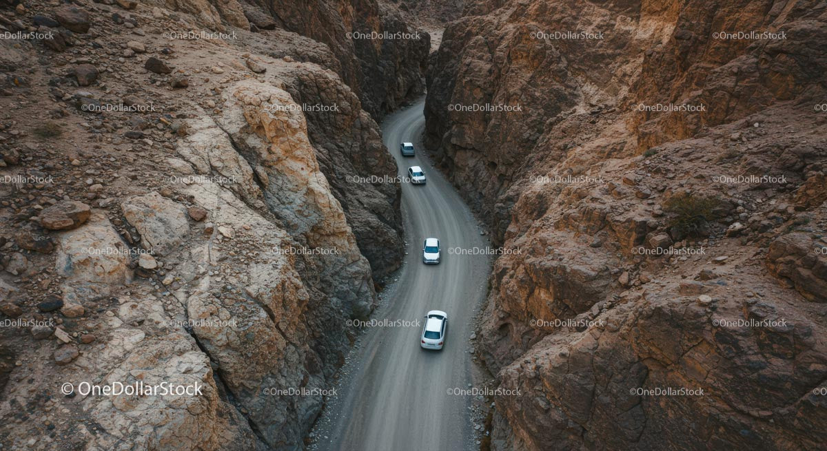 Cars Navigating Rocky Mountain Pass in Remote Desert