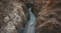 Cars Navigating Rocky Mountain Pass in Remote Desert
